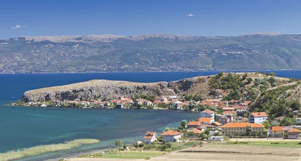 Ohridské jezero od pobřeží s červenými střechami domů — Stock fotografie