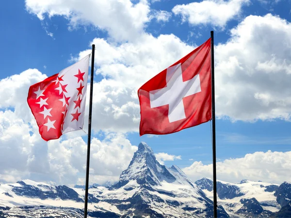 Svájci zászlók előtt matterhorn — Stock Fotó