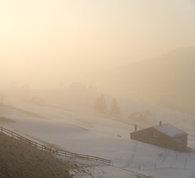 L wooden cabins in fog morning light clipart