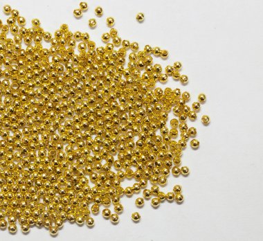 Gold jewelry beads from spilling on white background clipart