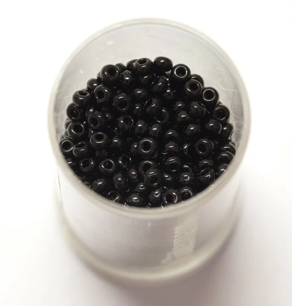 Stock image Black beads spilled from a jar