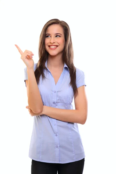 Smiling young brunette woman pointing at copyspace — Stock Photo, Image