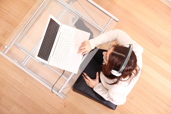 Vrouw met een laptop en hoofdtelefoon — Stockfoto