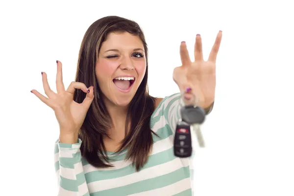 Fêmea étnica com chaves de carro e sinal de mão ok no branco — Fotografia de Stock
