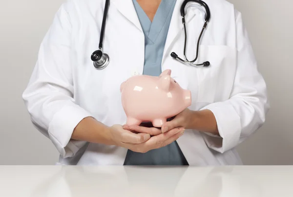Läkare med stetoskop anläggning piggy bank Sammanfattning — Stockfoto