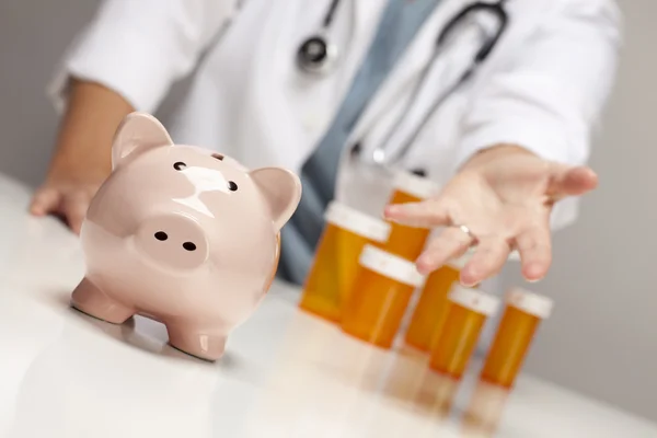 Doctor Reaches Palm Out Behind Medicine Bottles and Piggy Bank — Stock Photo, Image