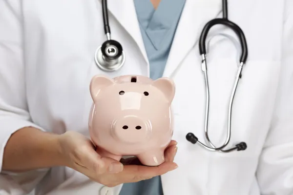 Médico con estetoscopio Holding Piggy Bank Resumen —  Fotos de Stock