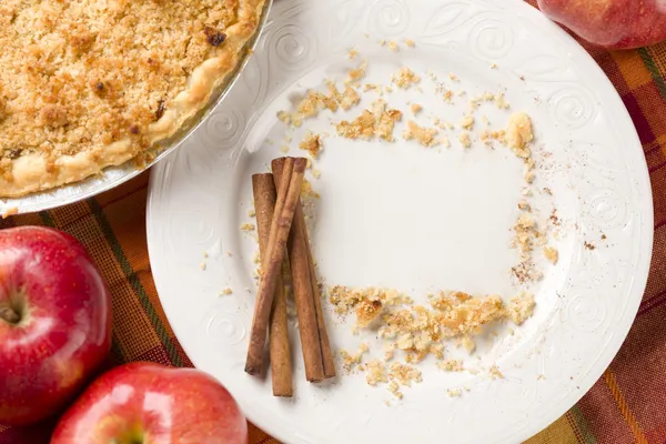 Пиріг, яблука, палички кориці та копію рівновіддалених крихти на тарілку — стокове фото