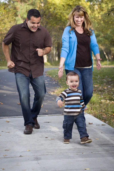 Happy Mixed Race Ethnic Family Walking In The Park Stockfoto