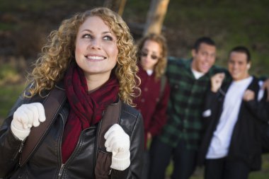 Pretty Young Teen Girl with Boys Behind Admiring Her clipart