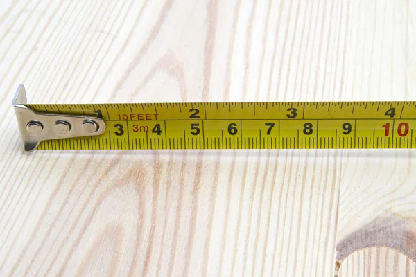 Fita métrica sobre fundo de madeira — Fotografia de Stock