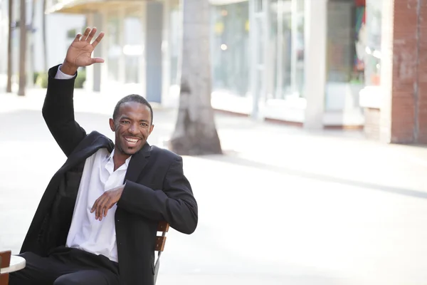 Чёрный бизнесмен машет рукой — стоковое фото