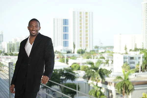 Jonge zwarte zakenman door de richel — Stockfoto