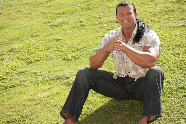 잔디에 앉아 행복 한 사람 — 스톡 사진