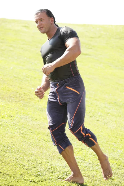 Homem atlético correndo no campo — Fotografia de Stock