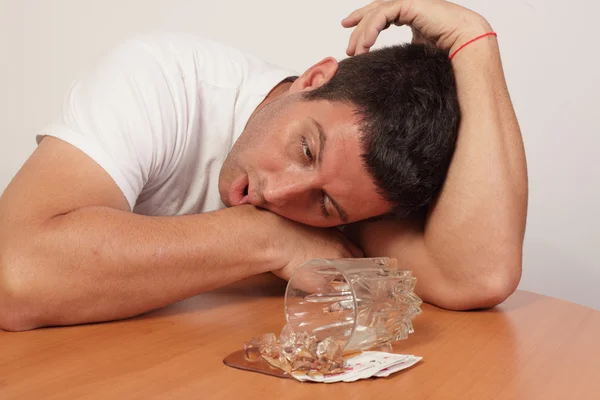 Alcoholic sleeping by his spilt drink — Stock Photo, Image
