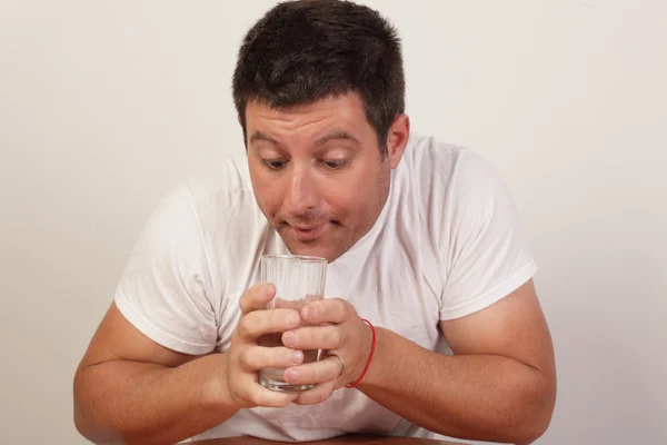 Homem segurando cuidadosamente um copo de água — Fotografia de Stock