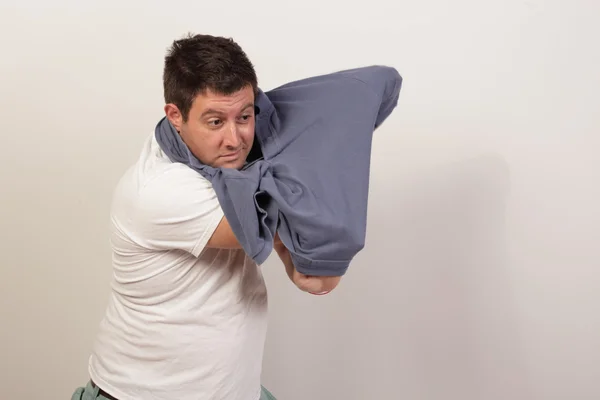 Az ember megpróbálja eltávolítani az ingét — Stock Fotó
