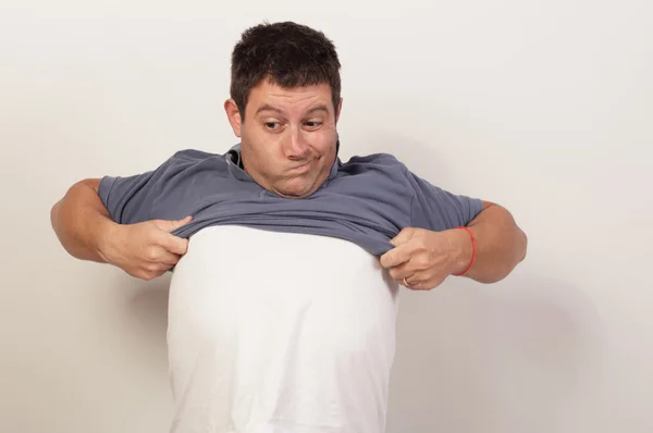 Człowiek stara się usunąć jego koszula — Zdjęcie stockowe