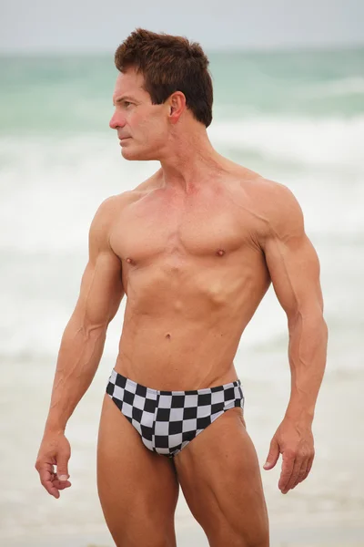 Attraktiva bodybuilder på stranden — Stockfoto