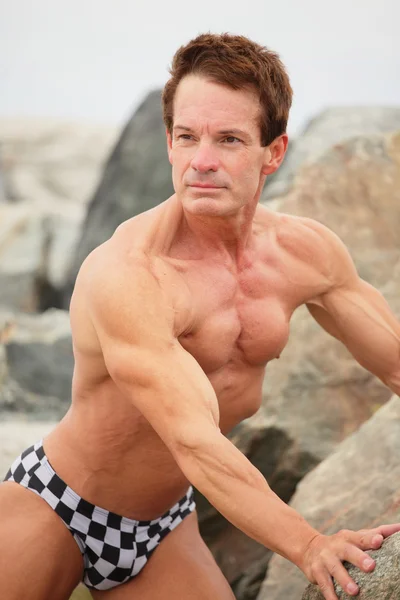 Bodybuilder on the rocks — Stock Photo, Image