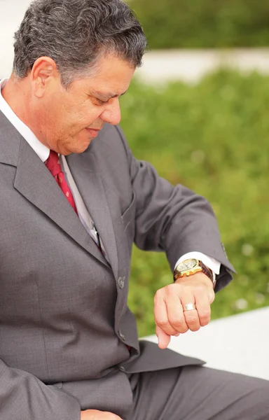 Бизнесмен смотрит на свои часы — стоковое фото
