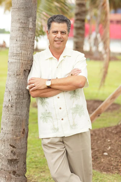 Man leaning on a palm tree — Stock Photo, Image