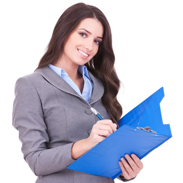 Business woman writing on clipboard — Stock Photo, Image