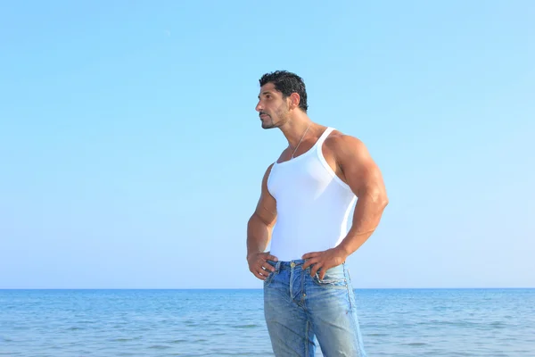 Hombre guapo en jeans junto al mar — Foto de Stock