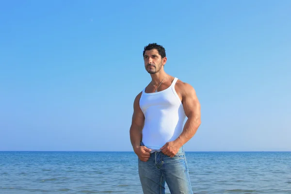 Красивий чоловік у джинсах біля моря — стокове фото