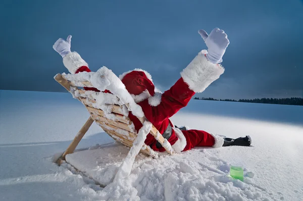 Weihnachtsmann entspannt sich auf der Sonnenliege — Stockfoto