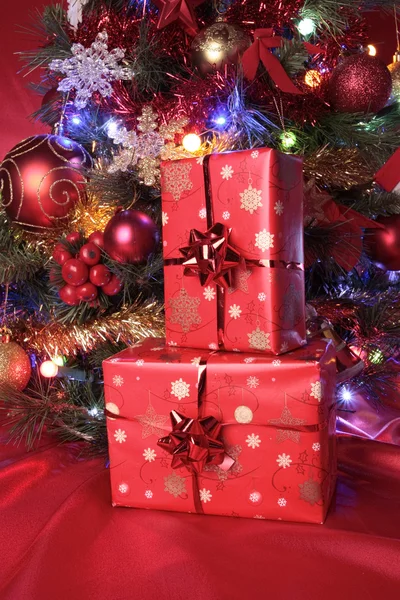 Χριστουγεννιάτικα δώρα και τις διακοσμήσεις δέντρων σε κόκκινο φόντο — Φωτογραφία Αρχείου