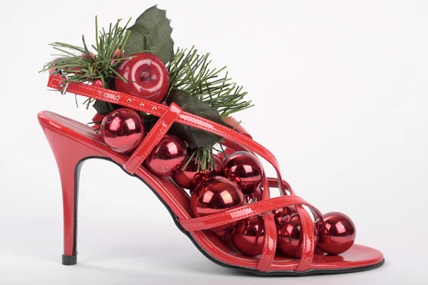 Červené boty na podpatku s vánočními dekoracemi — Stock fotografie