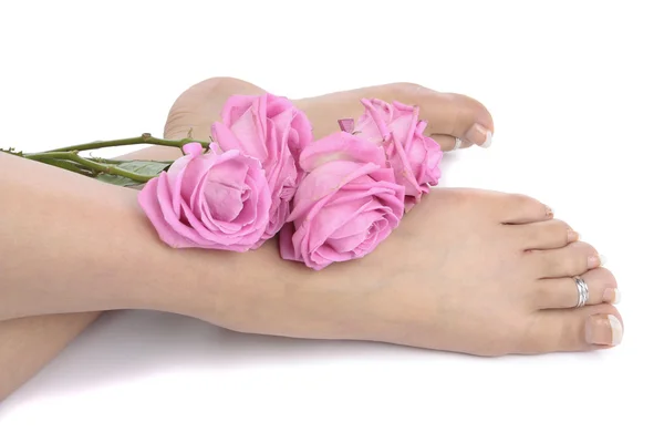 白い背景で隔離の花を持つ女性の足 — ストック写真