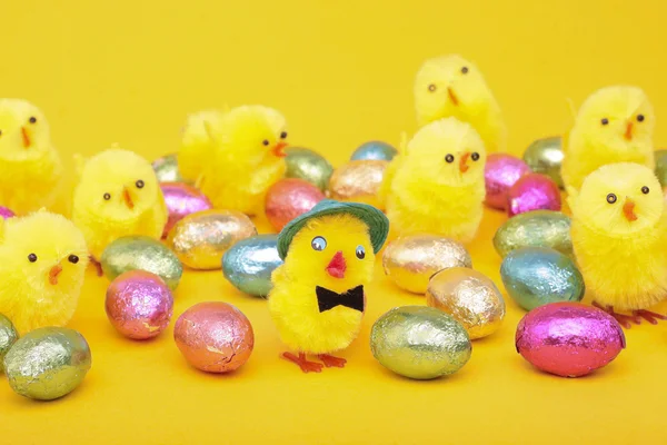 Pasen eieren en kuikens over geel — Stockfoto