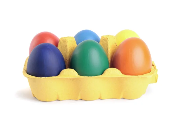 Цветные пасхальные яйца в коробке поверх белого — стоковое фото