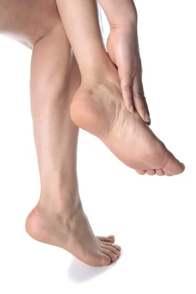 Žena nohy masírovat nohy izolovaných na bílém pozadí — Stock fotografie