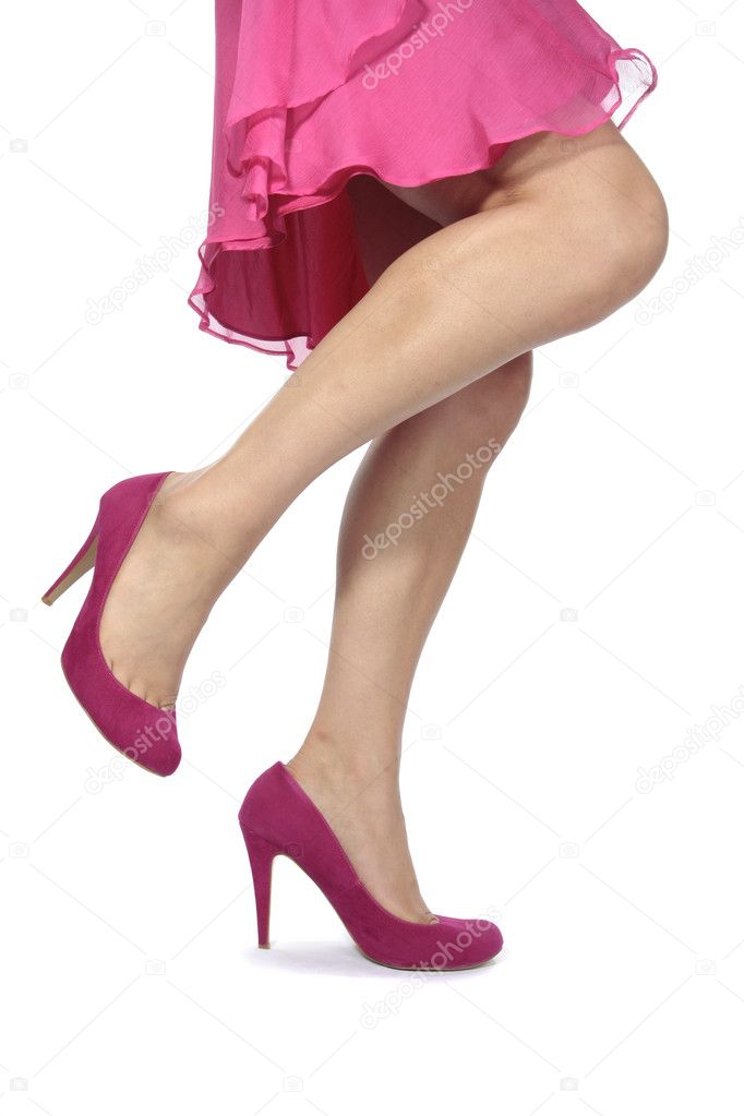 Woman legs pink dress and heels over white