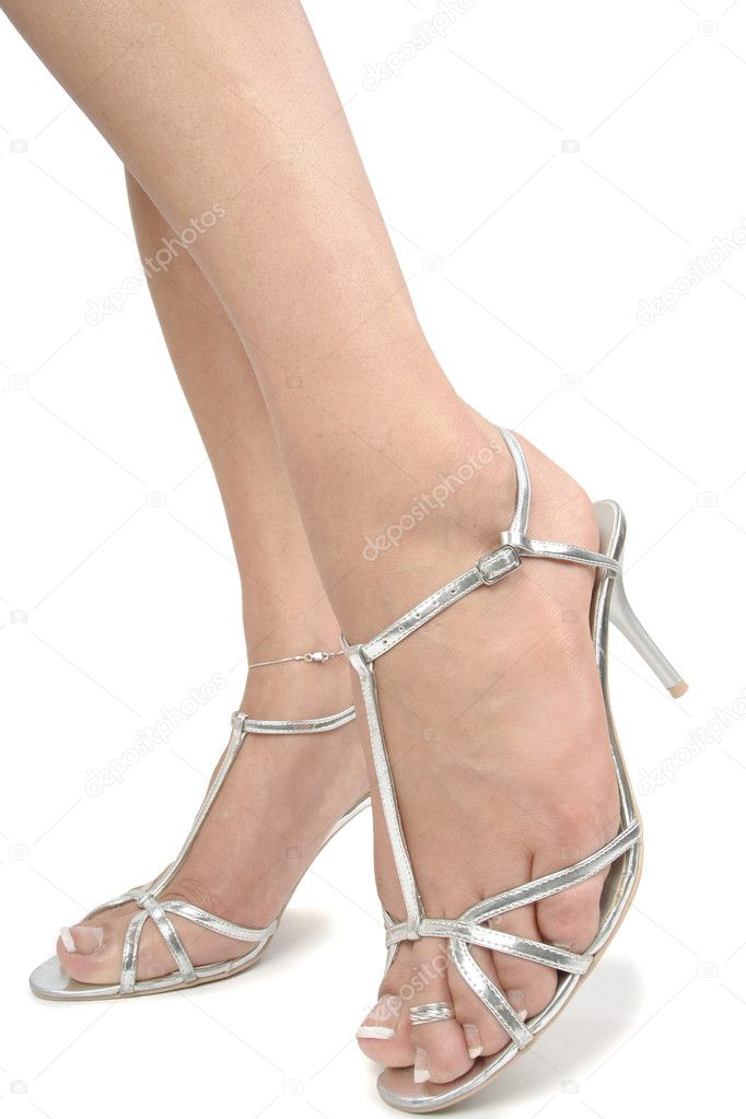 Woman legs wearing silver high heels over white background