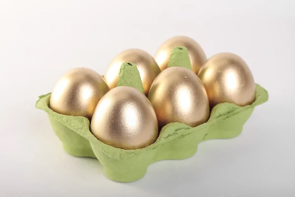 Золоті великодні яйця в коробі шпалерами білого кольору — стокове фото