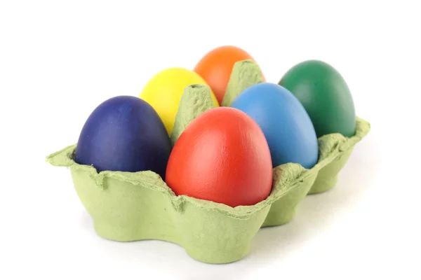 Barevné velikonoční vejce v kartonu přes bílý — Stock fotografie