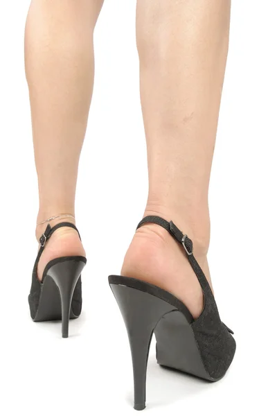 Kobieta nogi noszenia wysokich obcasów na białe tło — Zdjęcie stockowe