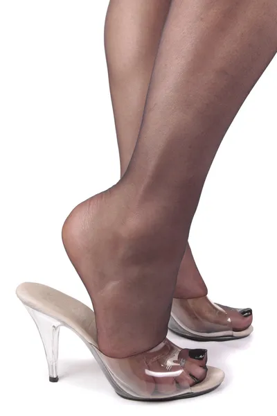 Женские ноги в колготках и чистые высокие каблуки на белом бэкгре — стоковое фото