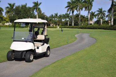 Empty golf cart by golf course clipart