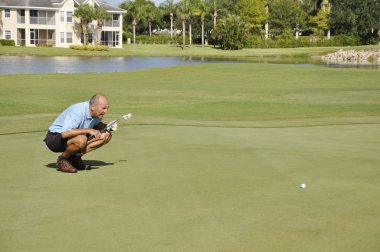 Man putting on a golf course clipart