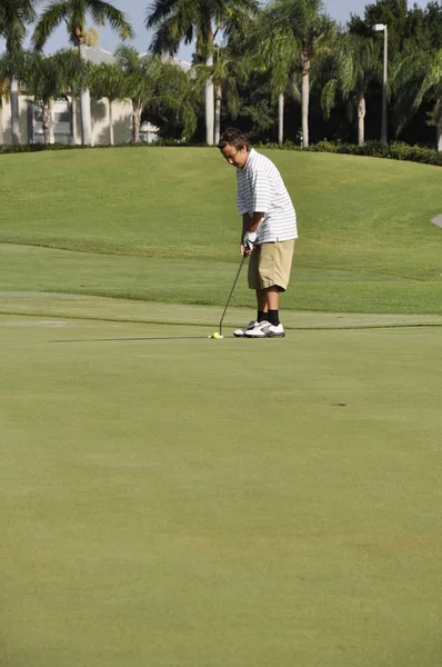 Adolescente chico poniendo en un campo de golf —  Fotos de Stock
