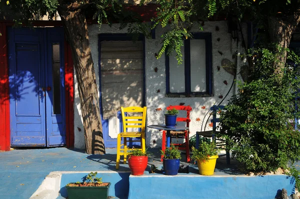 På det greske vertshuset med fargerike strandstoler – stockfoto