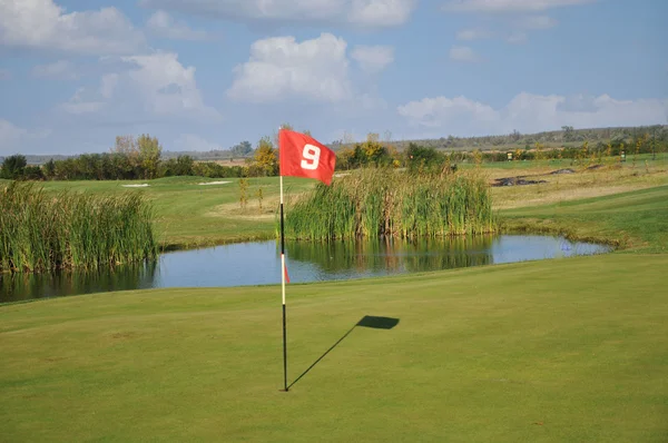 Campo de golfe com um lago — Fotografia de Stock