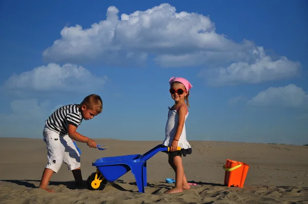 Meninas e um menino brincando na areia da praia — Fotografia de Stock