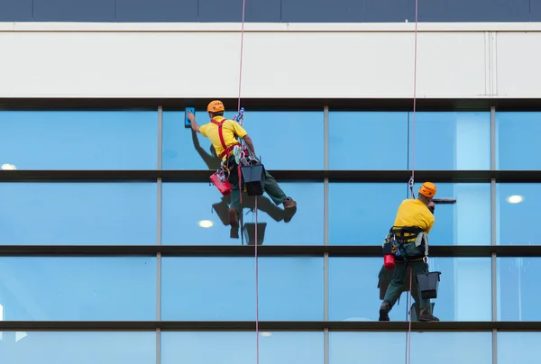 Двое рабочих моют окна — стоковое фото